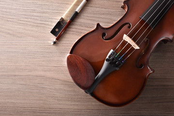 Violin body and bow with detail on wooden table top