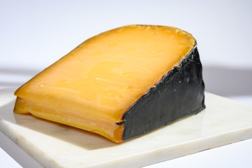 One piece of old Dutch gouda cheese with black wax
