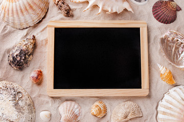 Wooden blackboard frame for drawing on the beach sand among the seashells