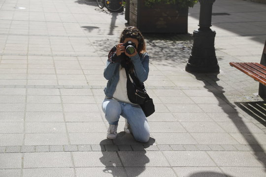 Woman taking pictures in the street