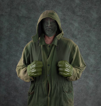 green man in a hood with green fists