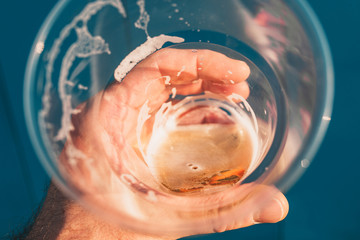 Glass of cold beer in hand - first-person view inward