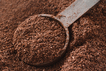 Rich coffee grinds and and measuring spoon
