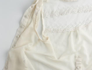 fragment of a silk beige blouse with lace and buttons