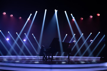 the piano on stage in the spotlight.