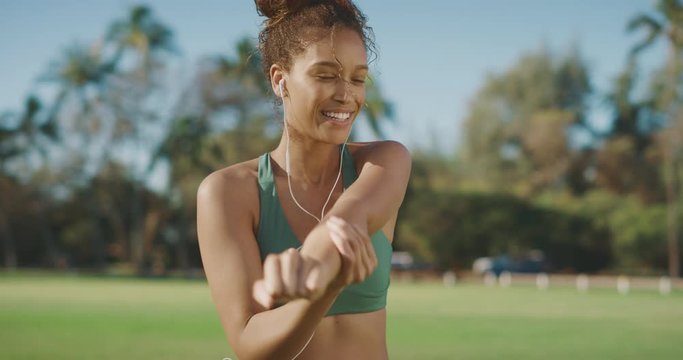 Smiling content african american woman stretching outdoors in the morning, athletic woman living a healthy lifestyle