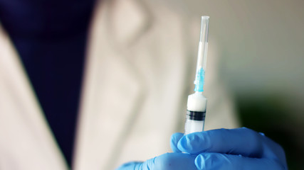Syringe needle injects intramuscular vaccine
