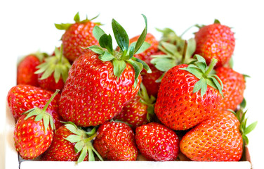 Fresh strawberries lie in a white wooden box. White background. Macro