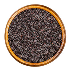 Siberian kale seeds in wooden bowl. Brassica napus var. pabularia. A leaf rape form variety, common as winter-annual vegetable. Seeds for sprouting. Macro food photo, close up, from above, over white.