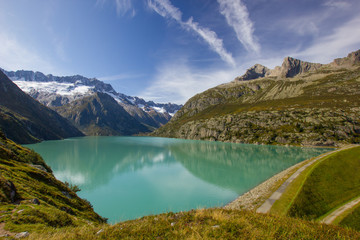 Lake Goeschenen in the swiss mountains with the dam on the rigth side