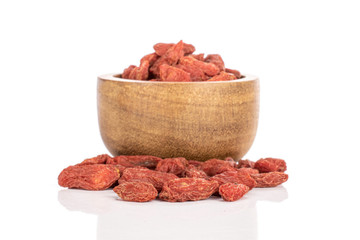 Lot of whole dried red goji berries in bamboo bowl isolated on white background