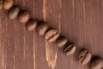Lot of whole fresh coffee bean flatlay on brown wood