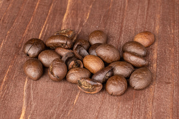 Lot of whole dark fresh coffee bean on brown wood