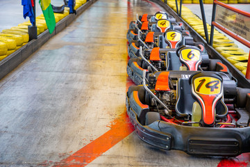 Row of karts with approval yellow numbers, ready to start inside a open track circuit