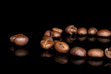 Lot of whole fresh coffee bean ring isolated on black glass