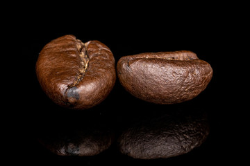 Group of two whole fresh coffee bean isolated on black glass