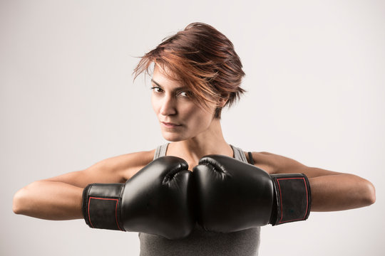 donna boxer felice  con i guantoni da boxe isolata su sfondo grigio chiaro