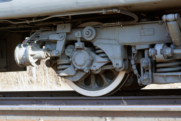 Fototapeta premium Wheel sets of a train stand on rails. A lot of parts, springs. Railroad, sunny day
