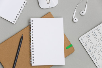 Minimal workplace with blank notebook keyboard and supplies on gray background. Top view. Flat lay