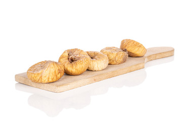 Group of five whole dried fig on wooden cutting board isolated on white background