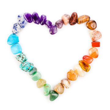 Heart made of colorful semiprecious gemstones isolated on a white background.