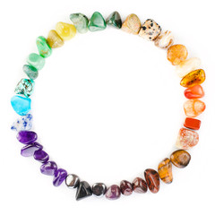 Circle made of colorful semiprecious gemstones isolated on a white background.