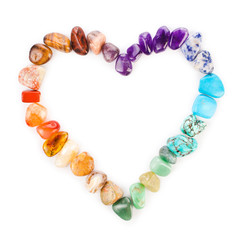Heart made of colorful semiprecious gemstones isolated on a white background.