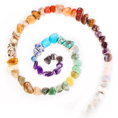 Spiral made of colorful semiprecious gemstones isolated on a white background.