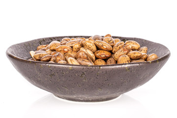 Lot of whole mottled brown bean pinto in glazed bowl isolated on white background