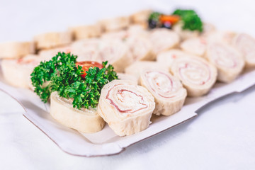 Ham roll ups on platter finger food buffet meal concept.