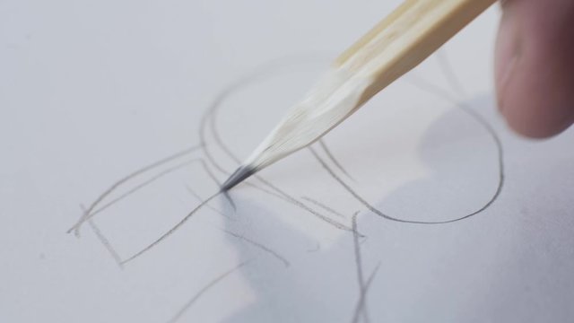 The designer makes a car sketch pencil on paper, draws a wheel and a hood