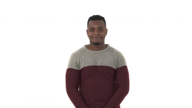 Hopeful millennial man joining hands in prayer, sending an air kiss, thanking asking for best. Isolated, on white studio background. Faith concept