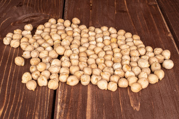 Lot of whole fresh tan chickpea on brown wood