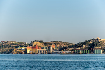 Colourful industrial shipping terminal on Tejo river in afternoon sun