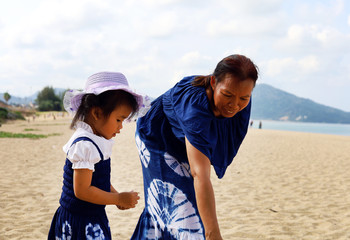 Beautiful Asia Grandma and girl are on the beach in holiday weekend at Phuket, Thailand.