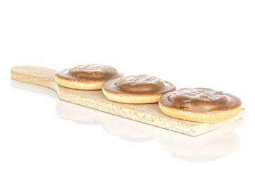 Group of three whole chocolate biscuit on wooden cutting board isolated on white background