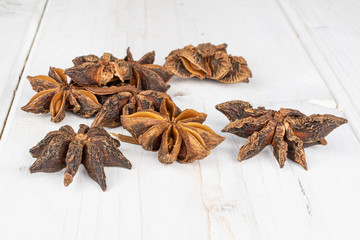 Lot of whole aromatic brown badian on white wood