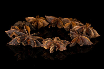 Lot of whole aromatic brown badian ring isolated on black glass