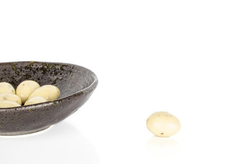 Lot of whole coated white almond nut stracciatella in glazed bowl isolated on white background