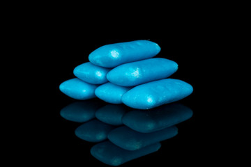 Group of seven whole blue chewing gum pyramid isolated on black glass