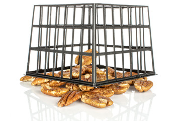 Lot of whole arranged tasty brown pecan half in black plastic basket isolated on white background