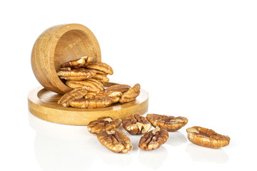 Lot of whole tasty brown pecan half in bamboo bowl on round bamboo coaster isolated on white background