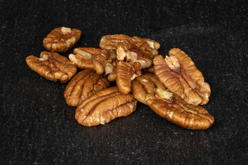 Lot of whole tasty brown pecan half on grey stone