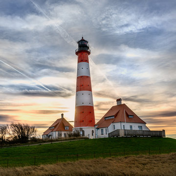 Lighthouse Westerhever at sunset with georgeous clouds and stunning colors at the North Sea in Schleswig Holstein, Germany