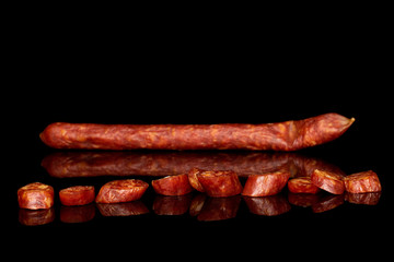 One whole lot of slices of piquant smoked sausage isolated on black glass