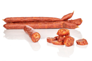Group of three whole one half lot of slices of piquant smoked sausage isolated on white background