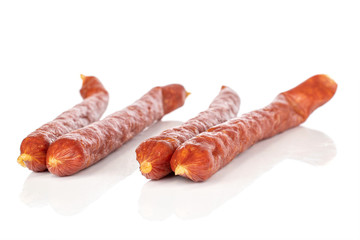 Group of four whole piquant smoked sausage isolated on white background