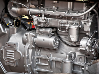 Silver colored pipes and parts on a tractor engine
