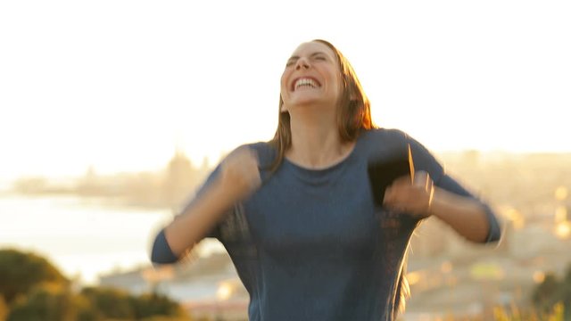 Front view portrait of an excited woman checking mobile phone celebrating 