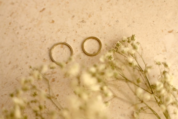 Two gold wedding rings on marble background. Selective focus.